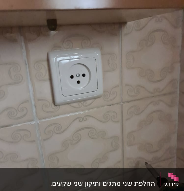 שקע חשמל על קיר עם מקדחה חשמלית
